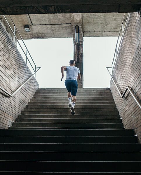 Young male athlete running up the stairs